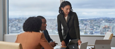 un uomo che discute con 2 donne e guarda lo schermo di un laptop