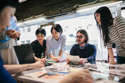 Group of people working together in a modern workspace in Tokyo.