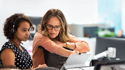 Twee personen die samenwerken aan een bureau met een Surface-apparaat