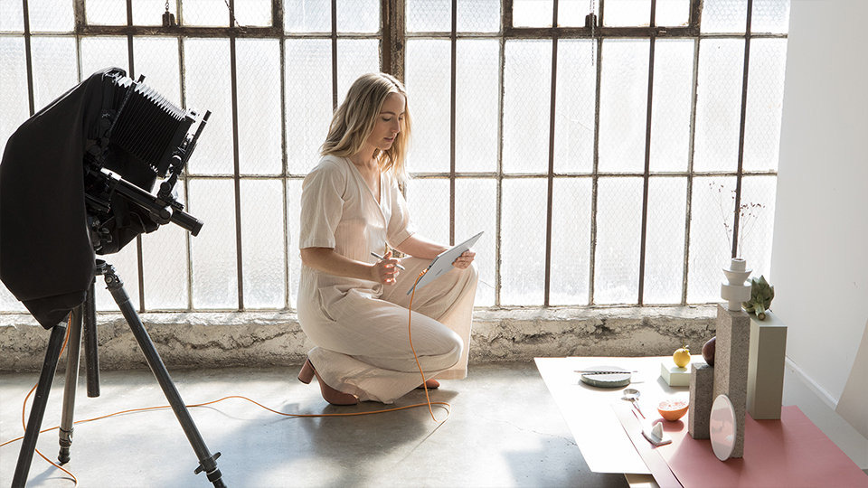 A woman uses Surface Pro 5th Gen for Business on a photo shoot.