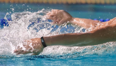 A person wearing the Samsung Galaxy Fit2 Smart Watch while swimming in a pool.