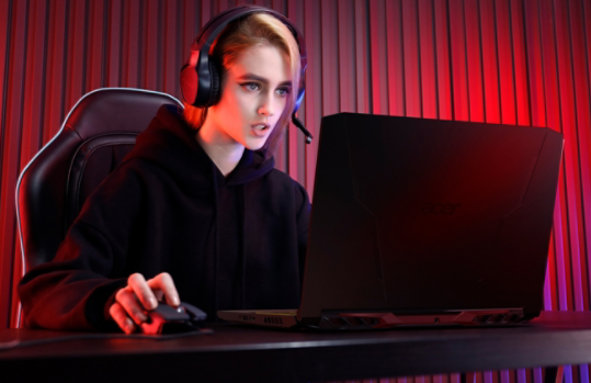 Gamer with a headset using an Acer Nitro 5 Gaming Laptop.