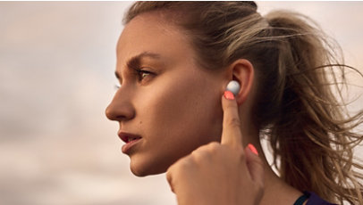 A person with the White Samsung Galaxy Buds 2 earbud in their ear.