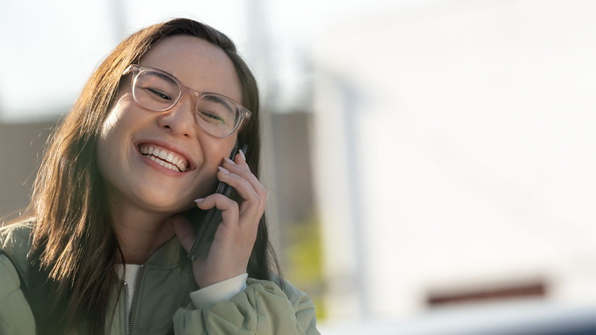 Une personne souriant en utilisant le Surface Duo 2 comme téléphone.