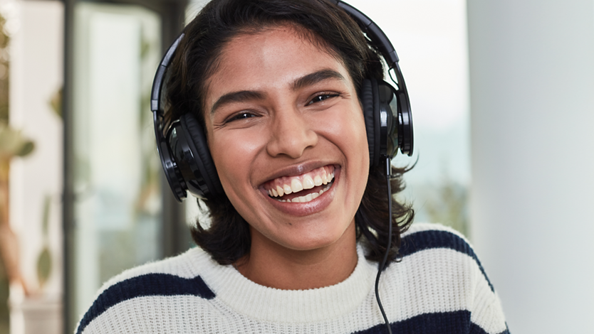 A gamer smiling and wearing headphones