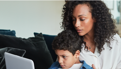 A parent and child using a laptop.