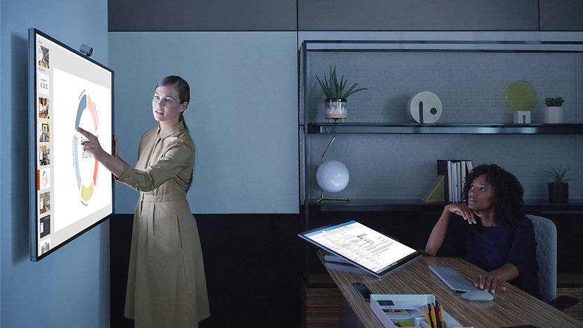 Zwei Führungskräfte arbeiten gemeinsam am Surface Hub 2S.