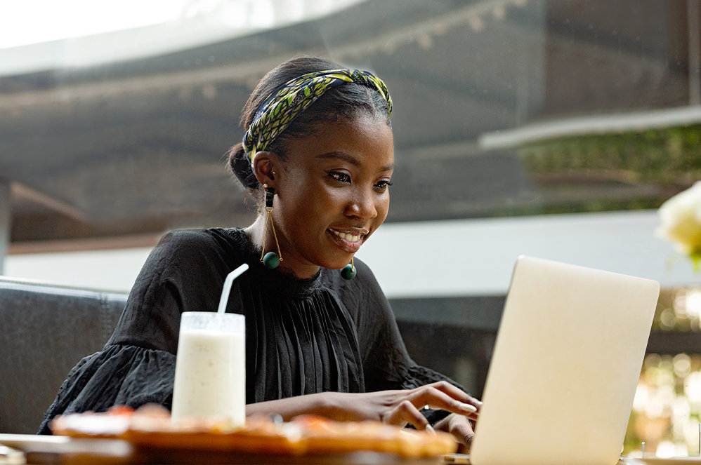 開いている Surface Laptop で Project Professional の進捗追跡機能を使用している女性