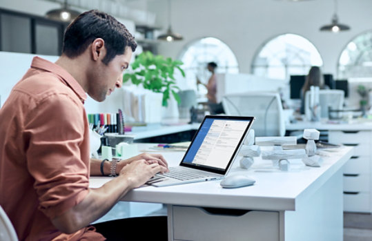オフィスで Surface Book を使用している男性