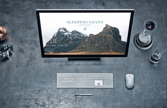 Surface Studio on a table with Surface Keyboard, Mouse and Pen.