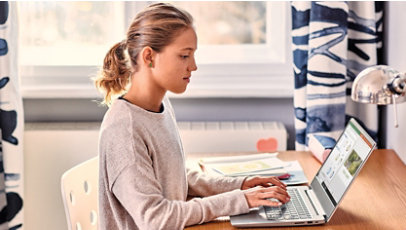 Osoba pracująca na urządzeniu Microsoft przy biurku.