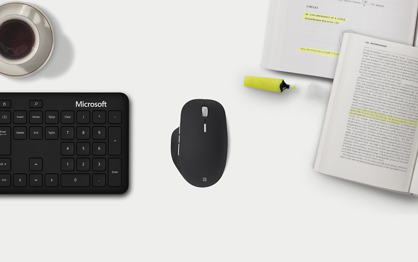 Microsoft Precision Mouse mit einem Microsoft Keyboard und einem aufgeschlagenen Buch.
