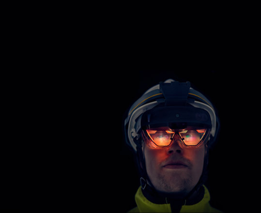 A person looks through the visor of a hardhat-integrated HoloLens 2. 