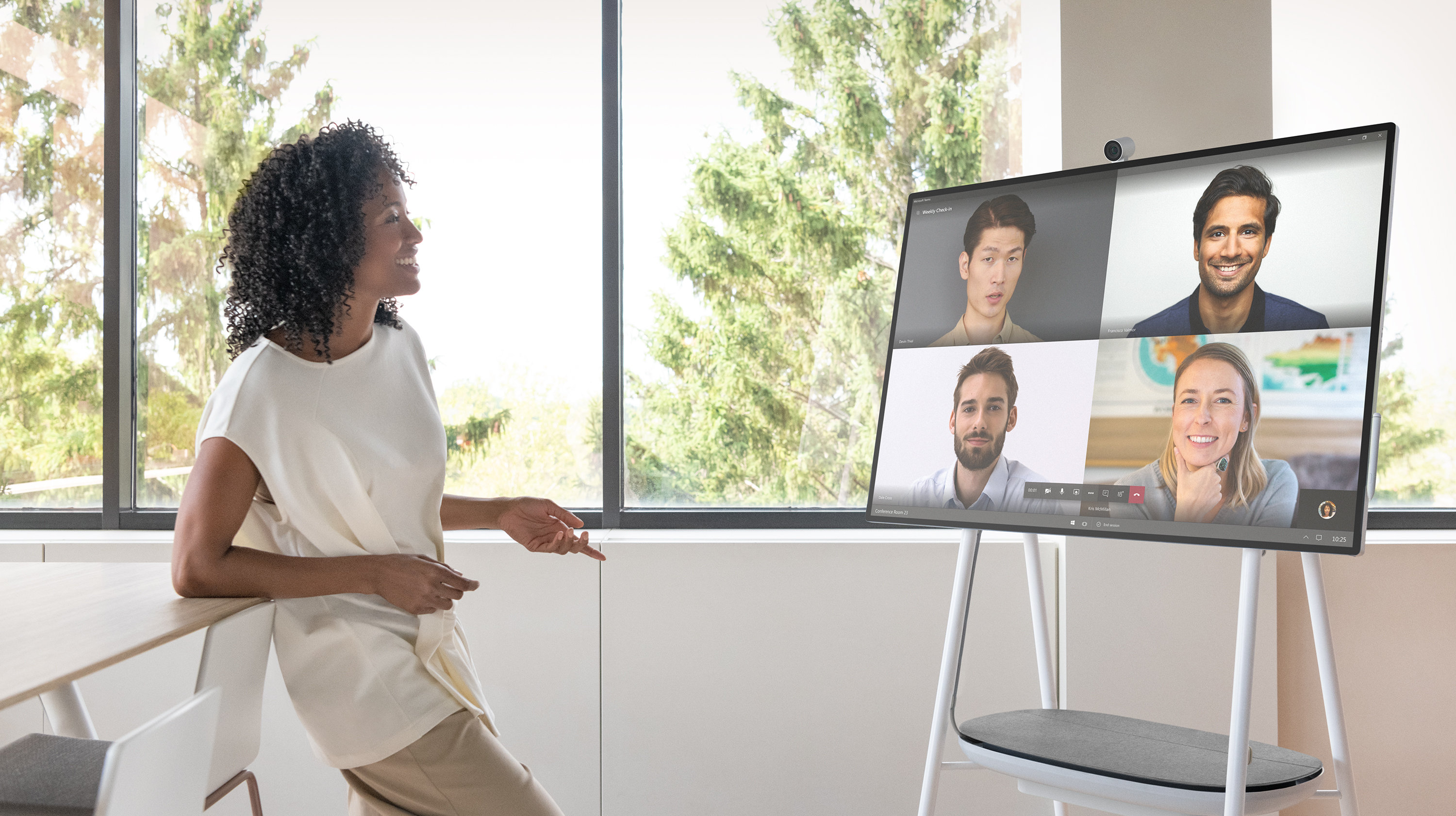 Eine Führungskraft verwendet Surface Hub 2S auf einem mobilen Stativ mit einem Akkupack.