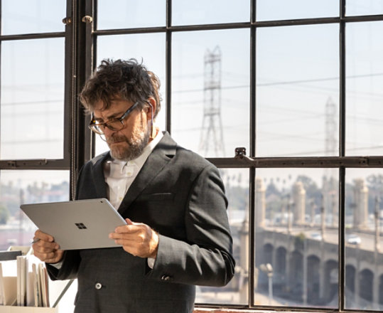 Un homme dans un bureau tenant un Surface Book 3.