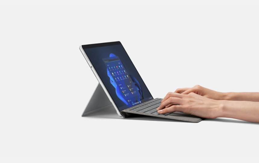 En persons händer skriver på ett Surface Pro Signature-tangentbord.