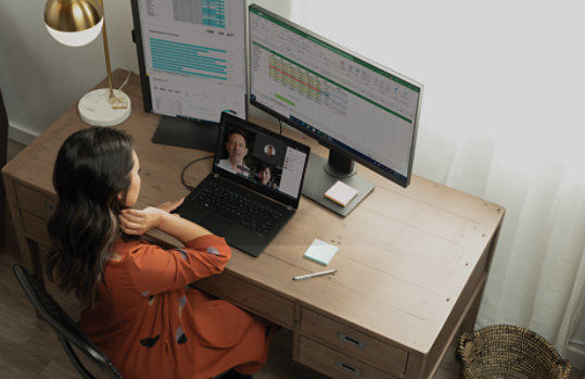 A woman using Teams and Excel.