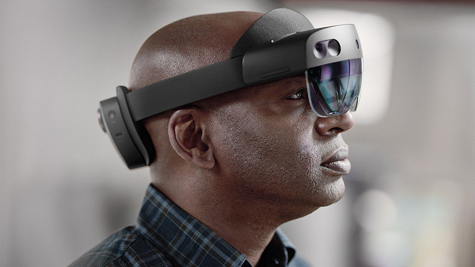 A man has his HoloLens device rested comfortably on his head.