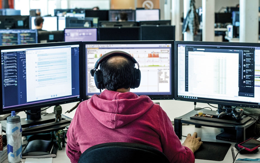 A developer uses Visual Studio on three computer monitors at work.