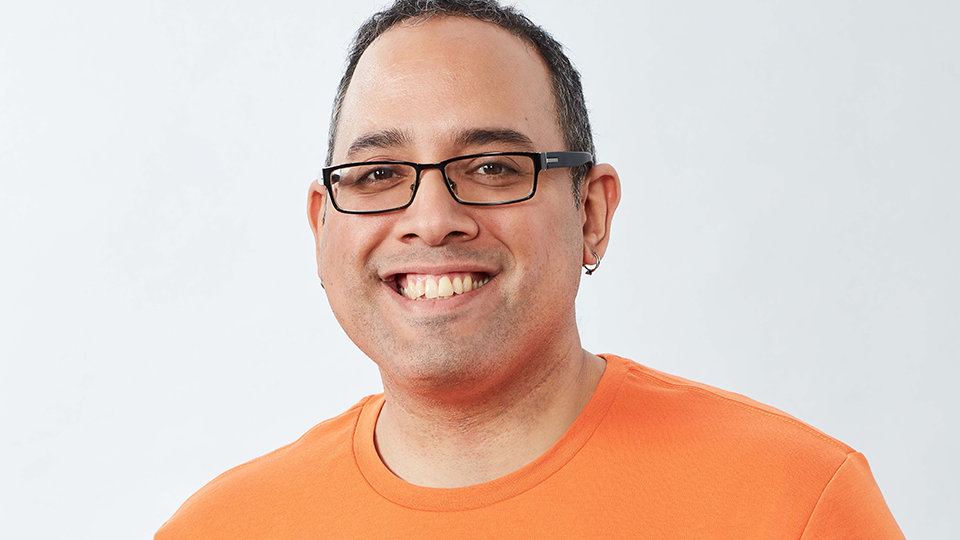 A person in an orange shirt smiling.