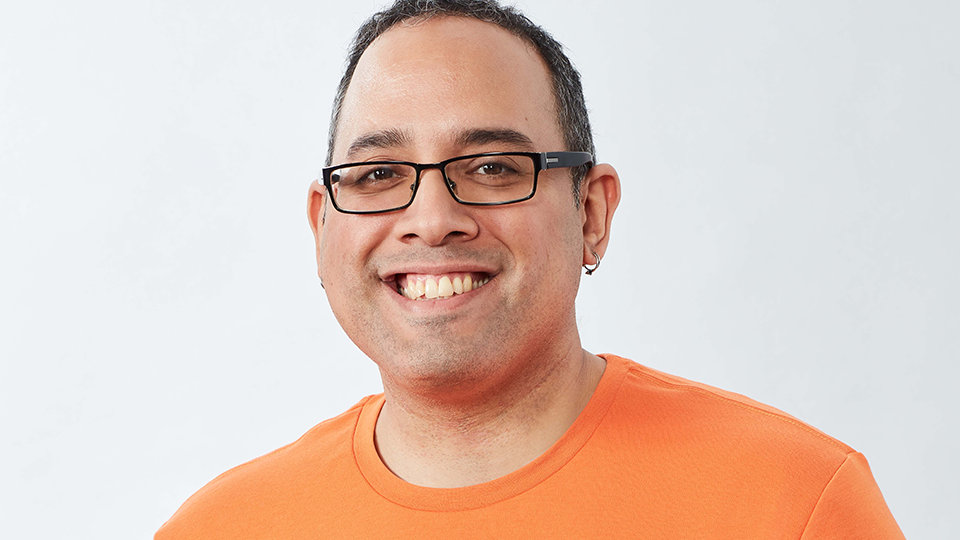 A person in an orange shirt smiling 