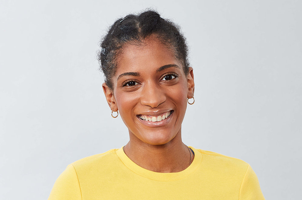 A person in a yellow shirt smiling.