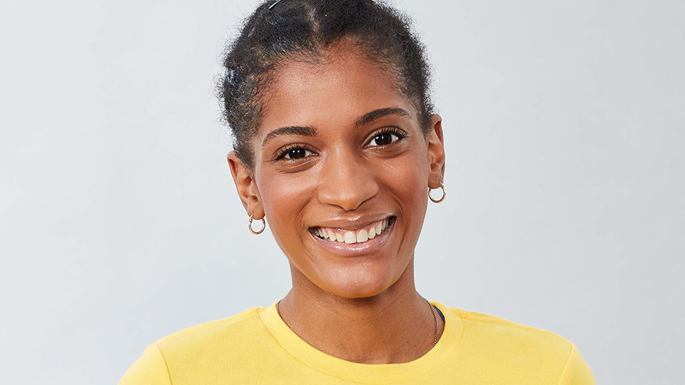 A person in a yellow shirt smiling. 