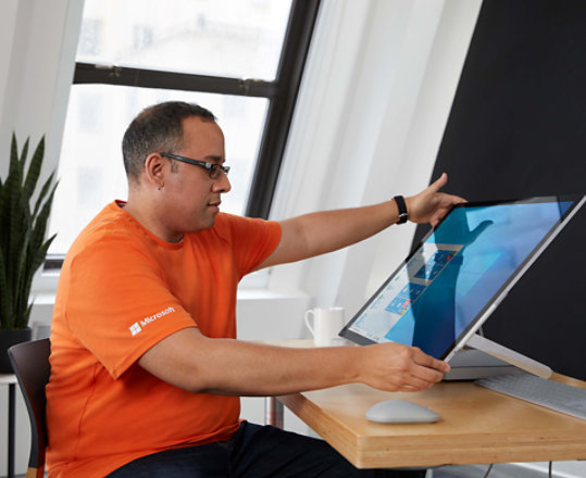 A person adjusting the screen of a Surface Studio device.