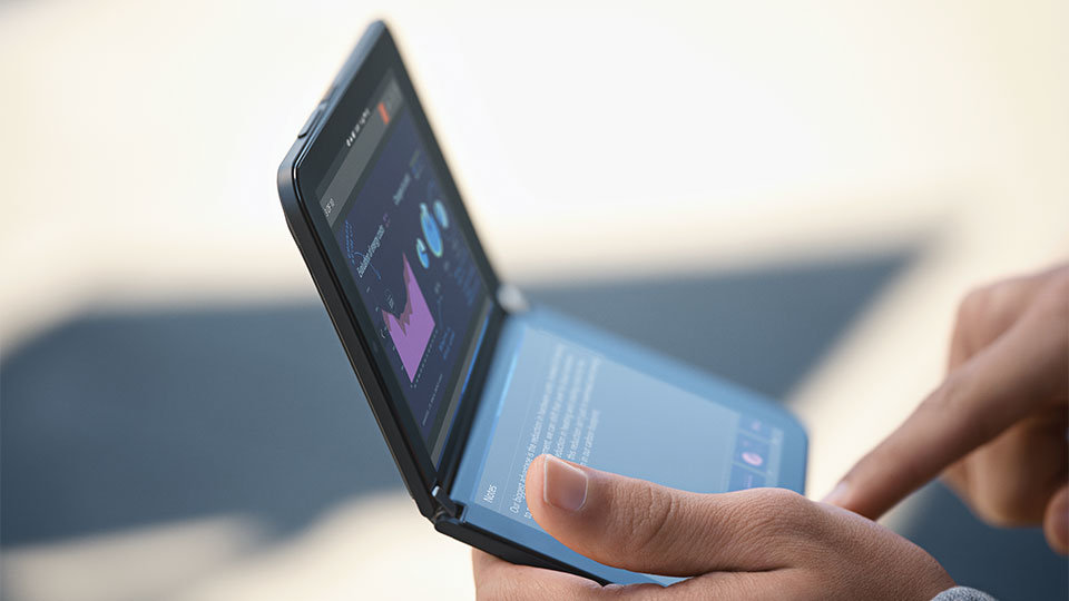 Un dispositivo Surface Duo 2 per le aziende, di cui si vedono entrambi gli schermi, tenuto fra le mani di una persona.