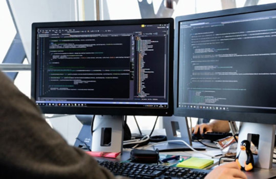 Man working on dual monitors