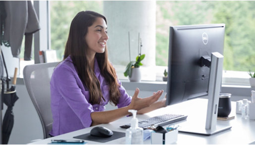 A person sits in front of a desktop computer.