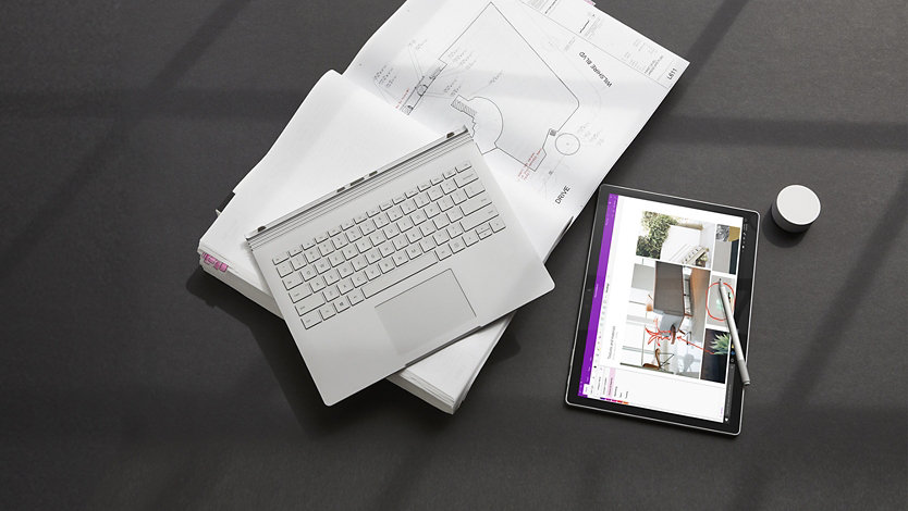 Ein Surface Book 3 Type Cover auf einem geöffneten Buch mit Touchscreen und schlankem Stift in der Nähe.