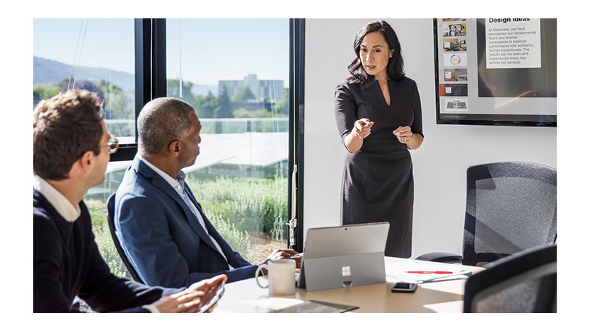 People in a corporate meeting with a Microsoft Surface device