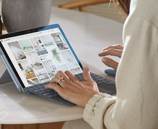 Eine Frau arbeitet von Zuhause an ihrem Surface Go 2 for Business im Laptop-Modus.