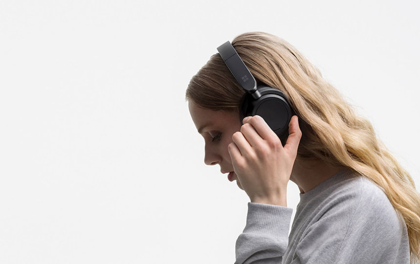 a woman turns the left dial on the left side of Surface Headphones 2