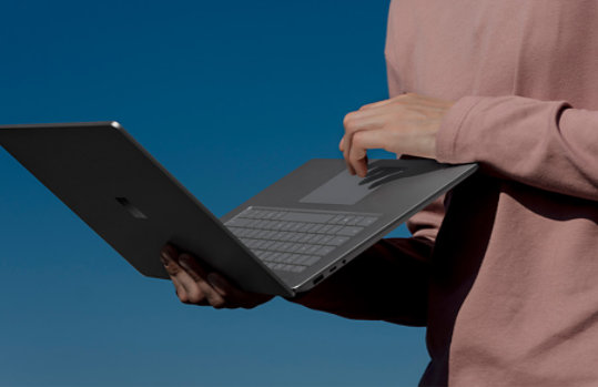 Person using holding Surface Laptop 3 while using the trackpad.
