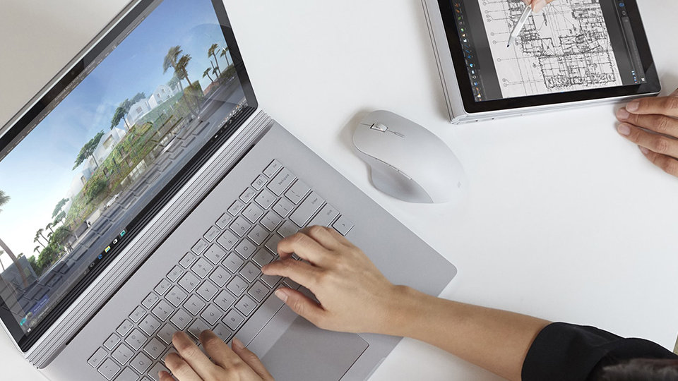Foto eines Surface Book mit einer Surface Precision Mouse daneben.