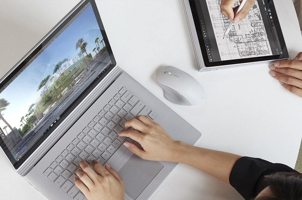 Foto eines Surface Book mit einer Surface Precision Mouse daneben.