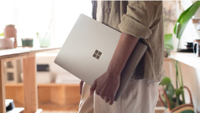 A person carries a refurbished Surface Laptop in a ceramics workshop.