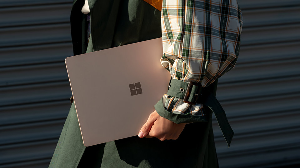 A person carries the Surface Laptop 3 with them on the go.