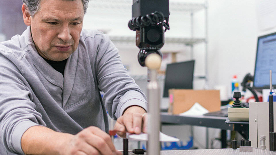 A person conducts an experiment with computer monitors in the background.