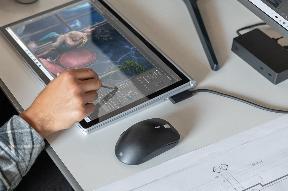 Surface Dock 2 を使用して、Surface デバイスを充電し、モニターに接続している人物