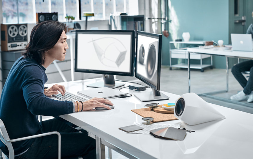 A person uses the Surface Mouse with a Windows device at a desk.