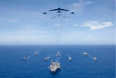 Militaire vliegtuigen vliegen over militaire schepen in de oceaan