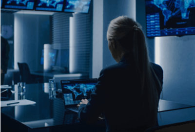 Een persoon die in een zwak verlichte kamer aan een bureau werkt