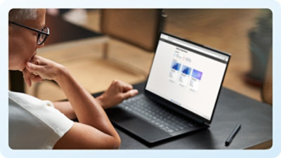A person in a white coat holding a laptop.