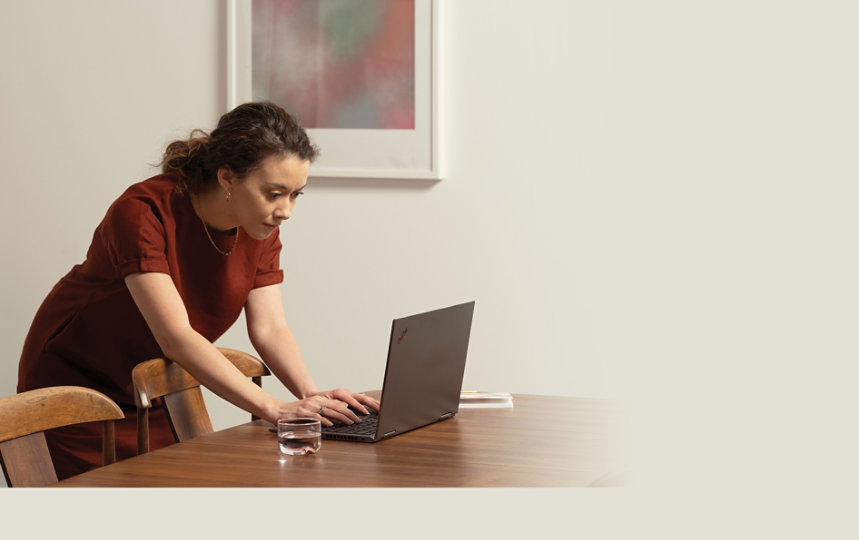 A woman using Microsoft 365 with a laptop on a conference room table.