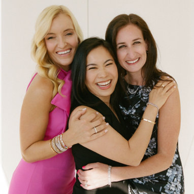 Three women embrasing one another: HCM founders