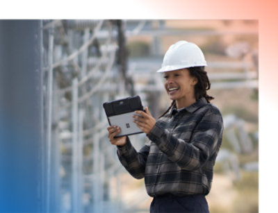 A person wearing a hard hat and holding a tablet