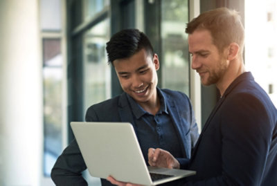 Two people looking at a laptop computer presumably discussing project accounting